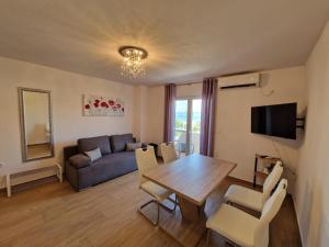 a living room with a table and a couch at Apartmani Natalija 4 Stars in Mrljane