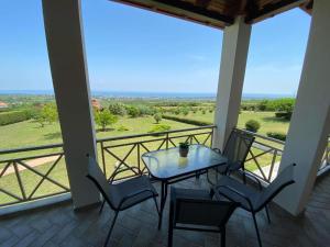 a table and chairs on a balcony with a view at Villa Amfitriti in Leptokarya