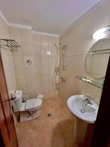 a bathroom with a sink and a toilet and a mirror at DebiMar in Chernomorets