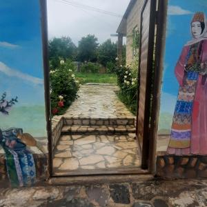 a painting of a path with a woman in a doorway at new garni 1 in Garni