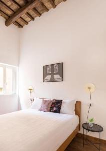 - une chambre blanche avec un lit et une table dans l'établissement Barberini Luxury Apartment, à Rome