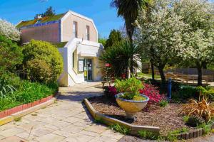 un jardin avec un grand pot devant un bâtiment dans l'établissement VVF Morbihan Larmor-Plage, à Larmor-Plage