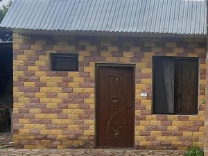 - un bâtiment en briques avec une porte et deux fenêtres dans l'établissement new garni 1, à Garni