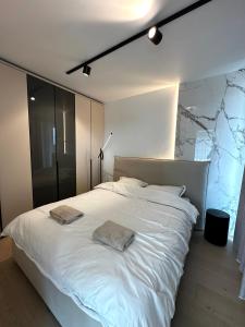 a bedroom with a large white bed with two towels on it at Sky Tower One in Ostend