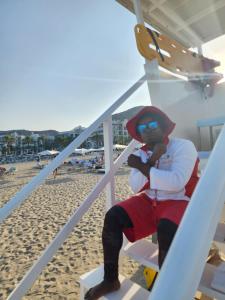 un homme assis sur une chaise sur la plage dans l'établissement Address Beach Resort Fujairah Apartment 2 Bed Rooms and Small Bed Room - Ground Floor 3011, à Al Aqah