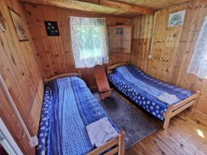 a bedroom with two beds in a wooden cabin at Splav Drina-Višegrad in Višegrad