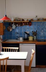 eine Küche mit blau gefliesten Wänden und einem Küchentisch in der Unterkunft Apartment bei der Tischlerei in Deutschlandsberg
