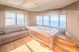 ein großes Bad mit einer großen Badewanne und Fenstern in der Unterkunft Kolin Hotel Spa & Convention Center in Canakkale