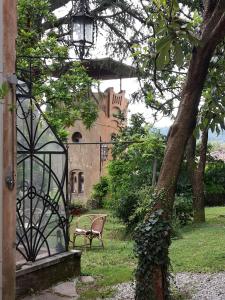 een poort naar een huis met een bank en een boom bij VILLINO AMELIATTE in Cison di Valmarino