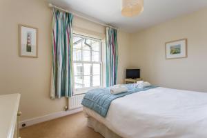 Un dormitorio con una cama grande y una ventana en Sands End, en Camber