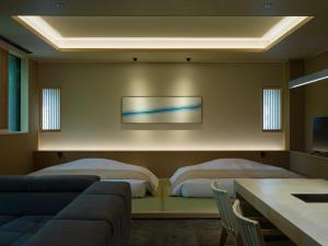 Suigan في Jozankei: غرفة معيشة بها سريرين وأريكة