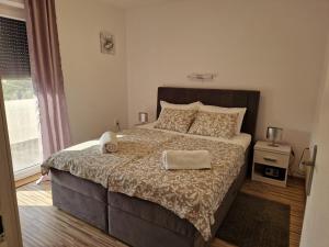 a bedroom with a large bed and a window at Apartmani Natalija 4 Stars in Mrljane