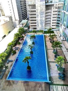 einen Blick über einen großen Pool mit Palmen in der Unterkunft Soho Suites KLCC By Sky Multilink in Kuala Lumpur