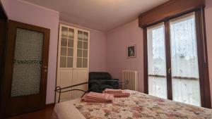 a bedroom with a bed and a chair and a window at Casa Lilla in Verona