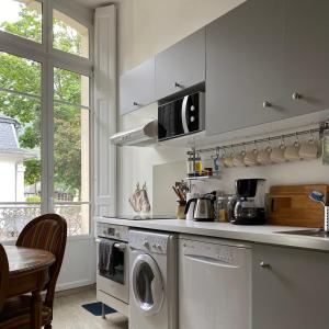 a kitchen with a washer and dryer in it at Ground Floor - Hauseman Building close to Thermes in Luchon