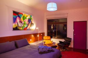 1 dormitorio con 1 cama de color púrpura y 1 silla en Vista Suite Treetops Silvan Valley Lodge en Silvan