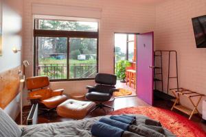 sala de estar con cama, sillas y ventana en Vista Suite Treetops Silvan Valley Lodge en Silvan