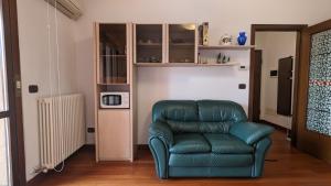una sala de estar con una silla de cuero verde y un microondas en Casa Lilla, en Verona