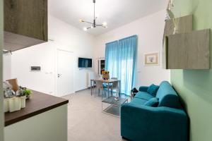 a living room with a blue couch and a table at Appartamenti vista mare Otranto in Otranto