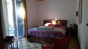 een slaapkamer met een bed en een groot raam bij chambre d'hôte chez l'habitant in Sète