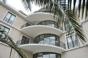 a building with balconies and a palm tree at Boutique Hotel Argo in Kutaisi