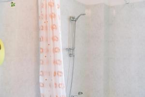 a shower with a shower curtain in a bathroom at Casa Antonietta in SantʼAnna Arresi +12 photos