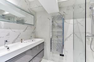 a white bathroom with a sink and a shower at Résidence Porte Maillot Arc de triomphe by Studio prestige in Paris