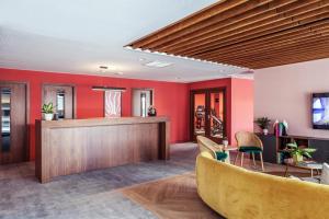 a lobby with red walls and a bar at Soto House Pamplona in Pamplona