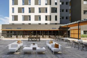 eine Terrasse mit Sofas und Tischen sowie ein Gebäude in der Unterkunft Soto House Pamplona in Pamplona