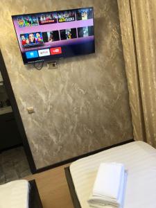 a room with a bed and a tv on a wall at Hotel LION Almaty in Almaty