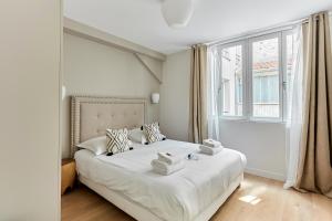 ein Schlafzimmer mit einem weißen Bett und Handtüchern darauf in der Unterkunft Résidence Porte Maillot Arc de triomphe by Studio prestige in Paris