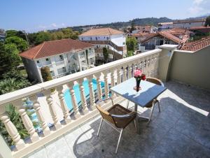 a balcony with a table with a vase of flowers on it at Hotel Villa Basil in Tsilivi