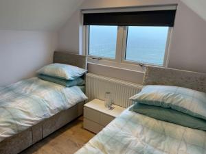 a bedroom with two beds and a window at Appaloosa suite with amazing views of stud farm. in Great Driffield