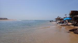 a beach with chairs and umbrellas and the ocean at CasaCanda king size in Somone