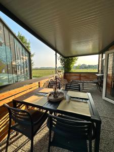 a patio with a table and chairs on a deck at BB HOUSE KOLPA RIVERSIDE in Metlika