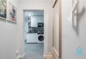 a kitchen with white cabinets and a washer and dryer at Whizzy Room in Gdańsk