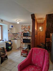 a living room with a red chair and a kitchen at Vivere in un bosco Casa Leonardo in Villar Perosa +12 photos