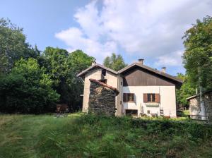an old house in the middle of a field at Vivere in un bosco Casa Leonardo in Villar Perosa