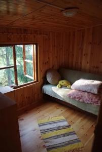 mały pokój z łóżkiem w drewnianym domku w obiekcie Okuninka Domek nad brzegiem jeziora Białe w Okunince