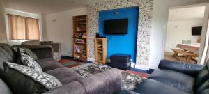 a living room with a couch and a tv at Walnut Tree View in Oxford