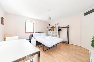 ein weißes Zimmer mit 2 Betten und einem Tisch in der Unterkunft Lovely Studio in Tower Hill, Fantastic location in London