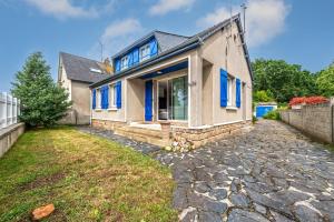 une maison avec des fenêtres bleues et une allée en pierre dans l'établissement KerMad - Maison avec jardin, à Le Relecq-Kerhuon