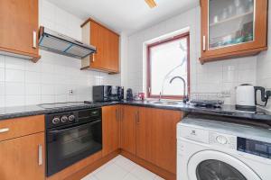 eine Küche mit einer Waschmaschine und einem Geschirrspüler in der Unterkunft Lovely Studio in Tower Hill, Fantastic location in London