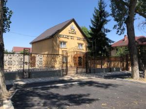 a house with a gate and a fence at Hotel LION Almaty in Almaty