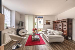 a living room with a white couch and a red rug at KerMad - Maison avec jardin in Le Relecq-Kerhuon