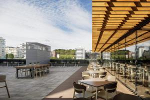 Soto House Pamplona في بامبلونا: مطعم بطاولات وكراسي على السطح