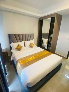 1 dormitorio con 1 cama blanca grande con almohadas amarillas en Parc21 Luxury Boutique Hotel en Phnom Penh