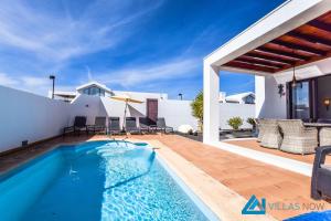 een villa met een zwembad en een patio bij Casa Carra - LH207 By Villas Now Ltd in Playa Blanca