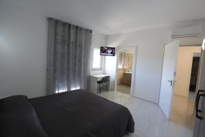 um quarto com uma cama e uma televisão de ecrã plano em Il Giglio em Castel Volturno