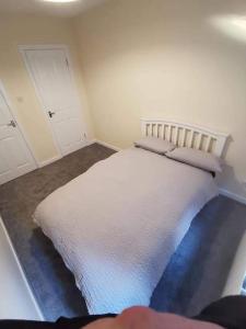 een slaapkamer met een wit bed met kussens erop bij Slateford Road Modern Apartment in Edinburgh